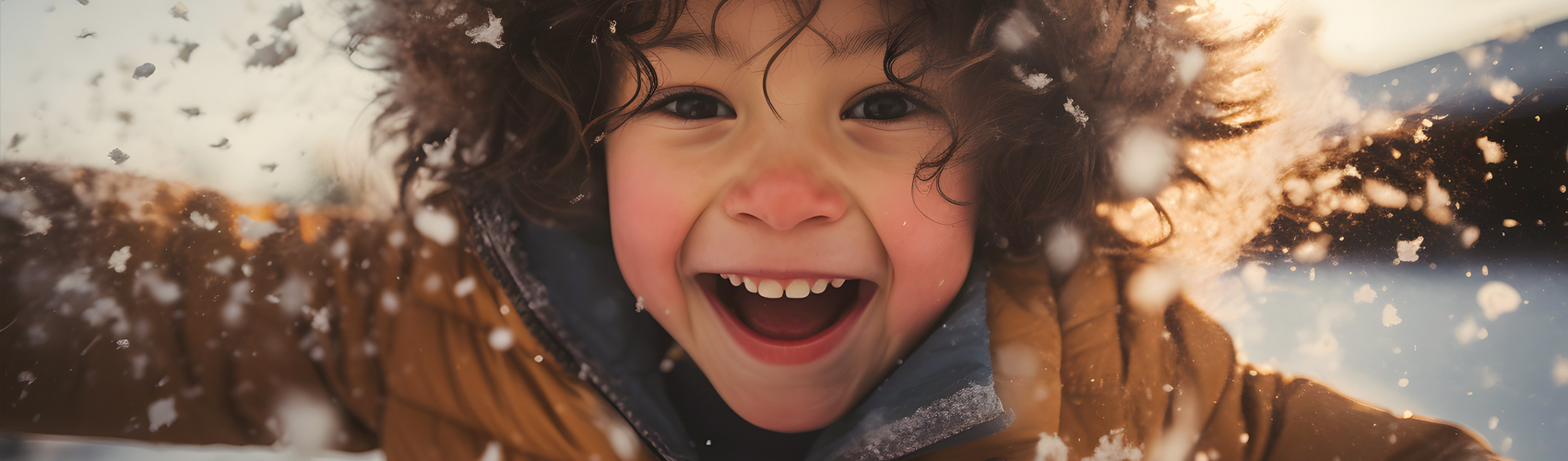 Kind mit freudigem Gesichtsausdruck tobt durch den Schnee